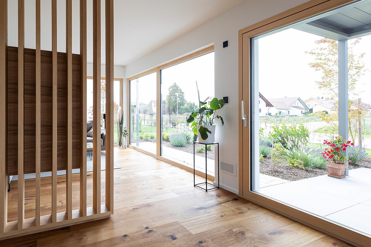 Innenaufnahme eines modern eingerichteten Wohnraums mit Blick auf große Fensterflächen
