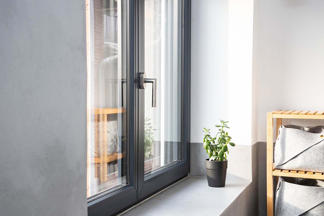 Nahaufnahme eines 2-flügeligem Badezimmer-Fensters aus dunklem Kunststoff