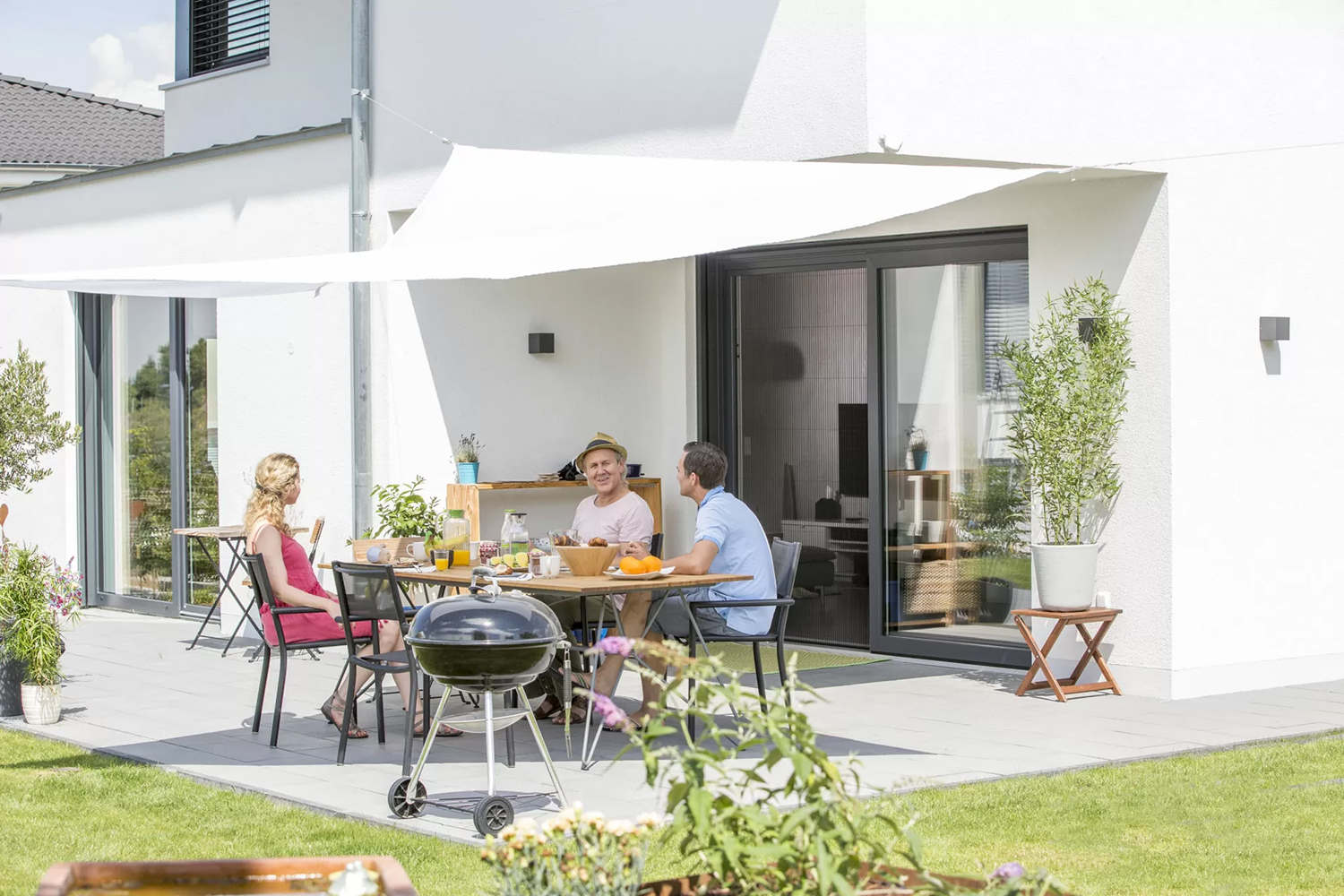 Eine Familie auf der Terrasse mit geschlossenem Plissee-Insektenschutz